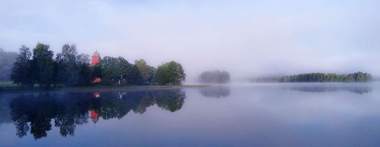 Svanskog church with morning mist over Mellan Svan